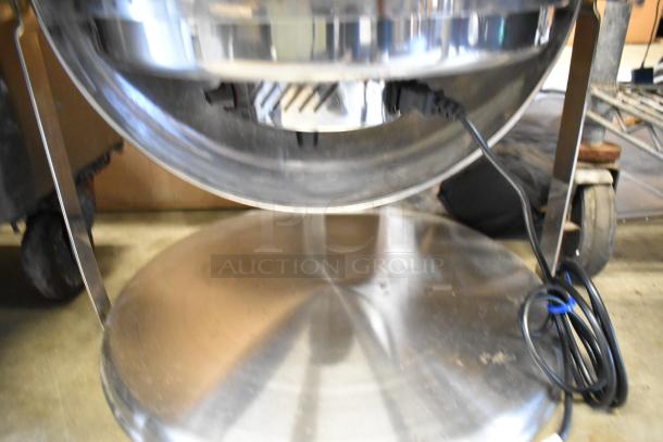 Metal round chafing dish with a polished finish, featuring a built-in electric heating element and sleek support legs.
