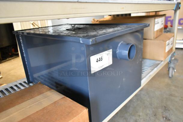 Brand new grease trap, metal construction, dark gray finish, with side pipe and label showing "446 QTY 1" from PCI Auctions.
