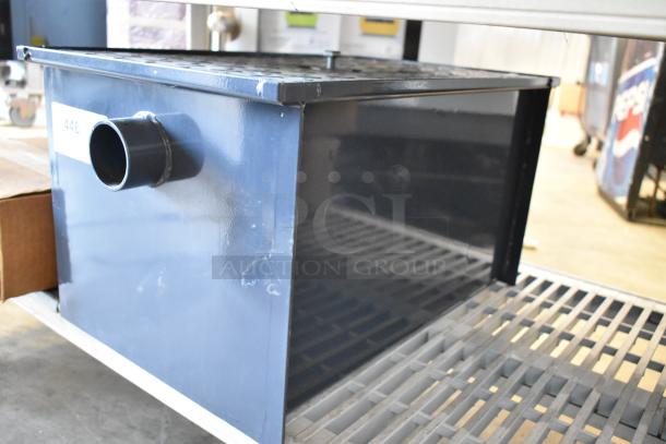 Brand new grease trap, metal construction, dark blue color, side pipe outlet, label with number 446.