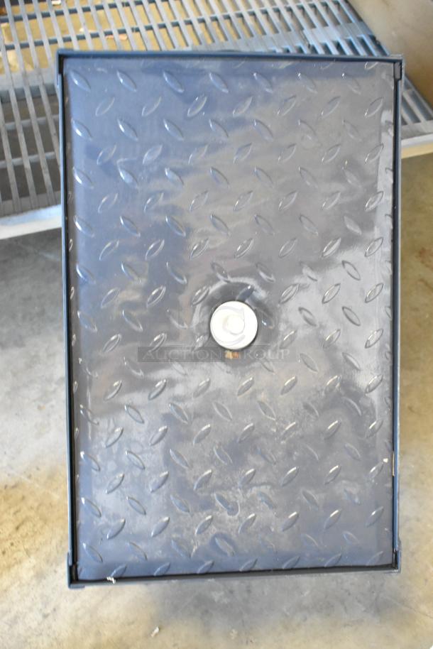 Brand new grease trap with diamond plate cover, featuring central bolt for secure closure. Durable industrial design.