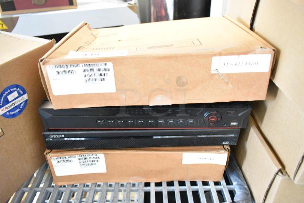 Four brand new items including Dahua network video recorders, in original packaging, featuring control buttons and USB ports.