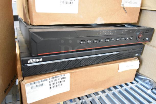 Brand new Dahua network video recorders stacked, featuring control buttons and labeled packaging, indicating high-tech security equipment.