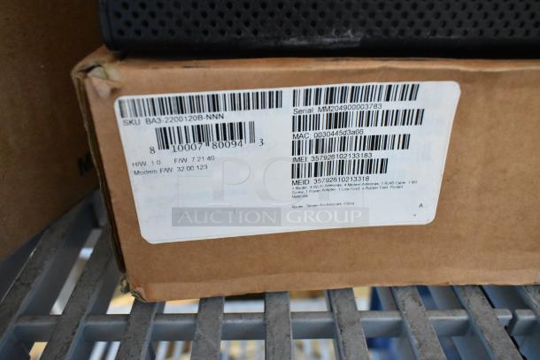 Cardboard box with attached label showing SKU BA3-2200120B-NNN. Includes details like serial, MAC, and IMEI numbers.