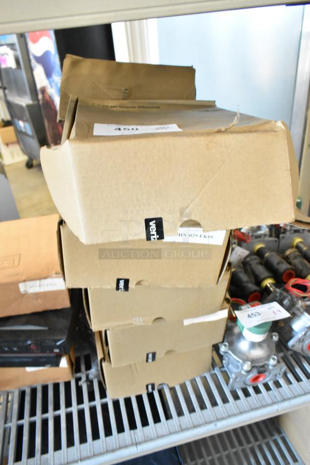 Stack of five new Verizon T41S IP Desk Phones in unopened brown boxes on a shelf, labeled and ready for auction.