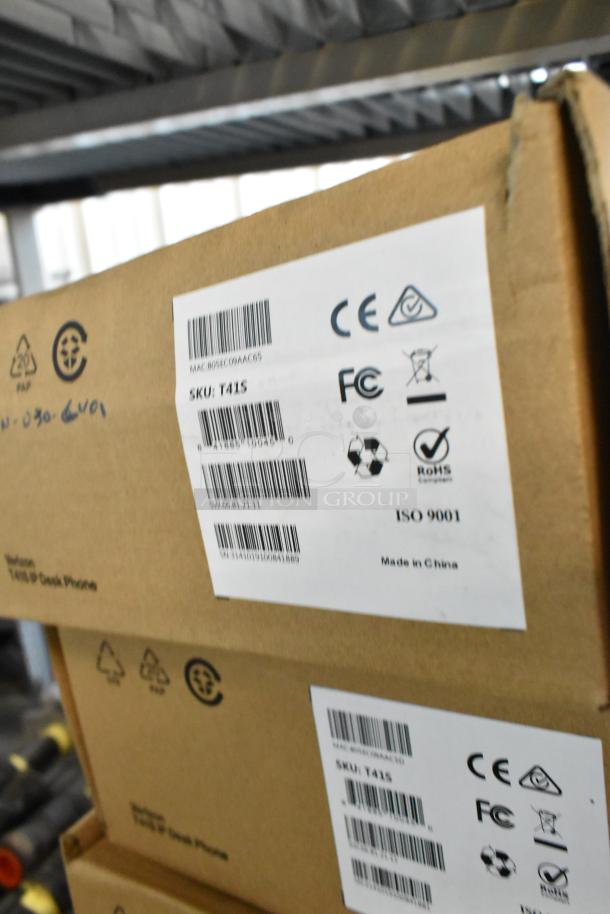 Boxes of Verizon T41S IP Desk Phones, brand new, labeled with CE, FCC, and RoHS compliance markings. Made in China.