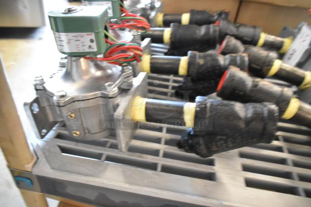 4 brand new Asco 323632 rebuild kits, shown on a metal rack. Each kit includes components and green control unit.