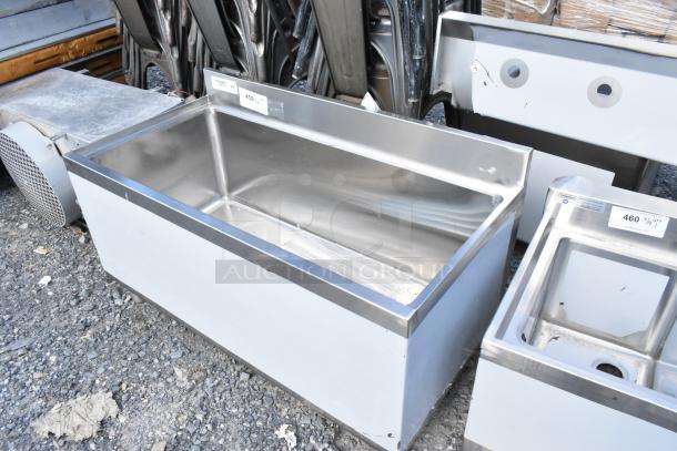 "Brand new Regency 600IB1836 18x36 underbar ice bin, 119 lb capacity, no legs, stainless steel, visible scratches and dents."