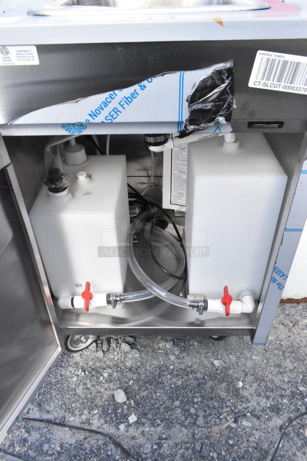 Brand new QualServ WMSC24MS stainless steel portable sink, partially wrapped, visible water tanks, minor scratches, on wheels.