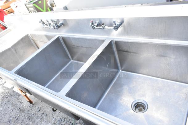 Stainless steel 3 bay sink with dual drain boards, faucets, in used condition. Ideal for commercial kitchens.
