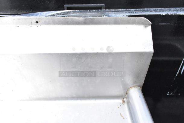 Stainless steel 3 bay sink with visible edge, showing durable construction and slight wear. Includes dual drain boards.