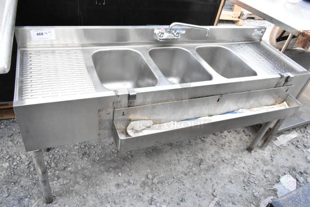 Stainless steel 3 bay back bar sink with dual drain boards and speewell. Features faucet, slight rust on exterior.