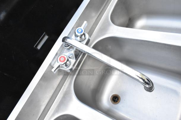 Stainless steel 3 bay back bar sink with dual drain boards and speewell, featuring separate hot and cold faucets.