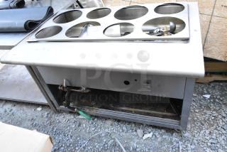 Stainless steel commercial steam table with six compartments, showing some wear. Ideal for catering or restaurant use.