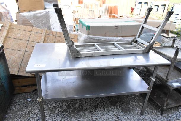 Stainless steel table with under shelf, industrial-grade, used condition, featuring sturdy legs and a clean surface.
