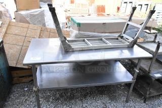 Stainless steel table with under shelf, industrial-grade, used condition, featuring sturdy legs and a clean surface.