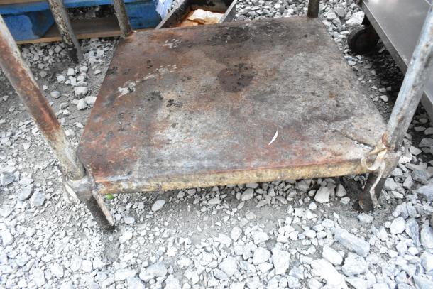 Stainless steel equipment stand with under shelf, showing heavy rust and wear. Suitable for industrial use.