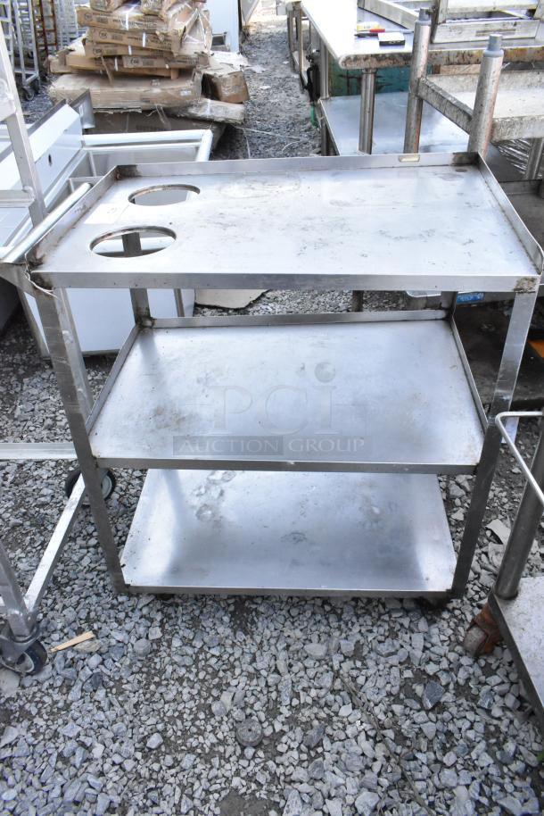Metal 3-tier cart on commercial casters, features sturdy shelves and built-in bottle holders, used condition with visible wear.