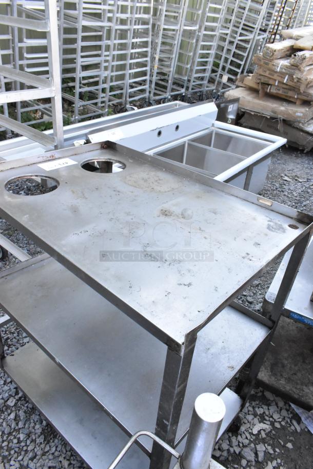 Metal 3-tier cart on commercial casters, showing signs of wear, with round cutouts on the top tier.
