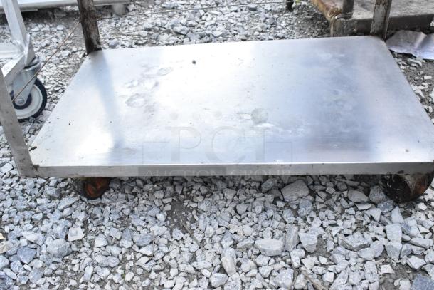 Metal 3 tier cart with commercial casters, showing a sturdy first shelf. Surface wear visible, ideal for heavy-duty use.