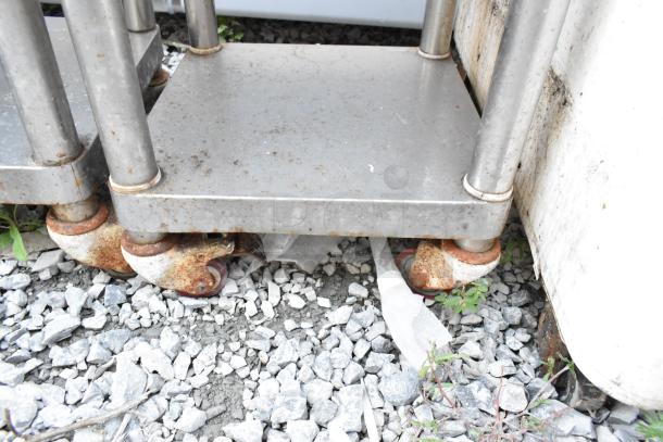 Two stainless steel rice cooker stands with commercial casters, showing signs of rust and wear.