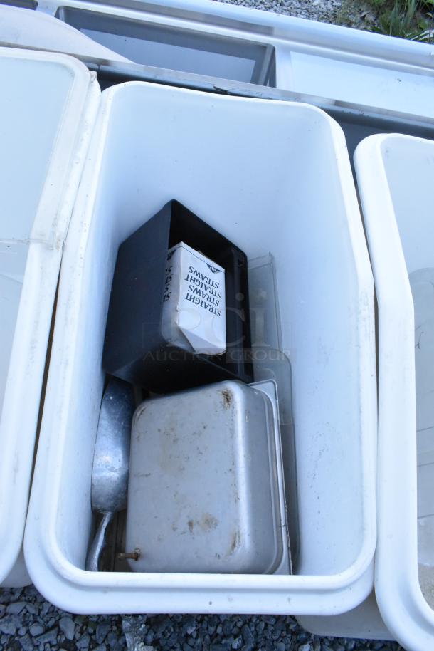 Four white poly ingredient bins with casters, used condition. Contains a scoop and container. Ideal for bulk storage.