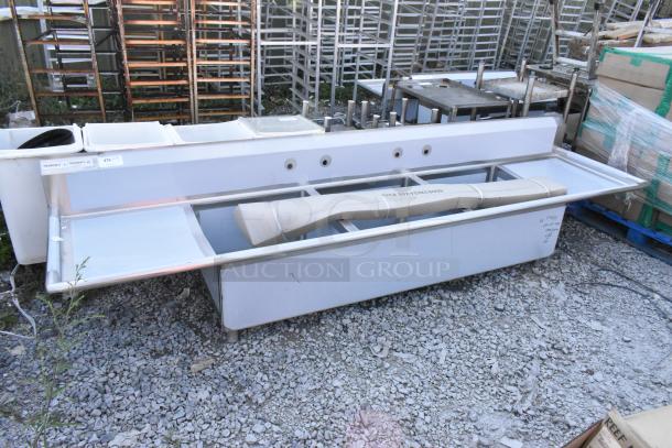 Brand new Regency 600S3242424S stainless steel 3 bay sink with dual drainboards. Minor dents visible, tags display model info.
