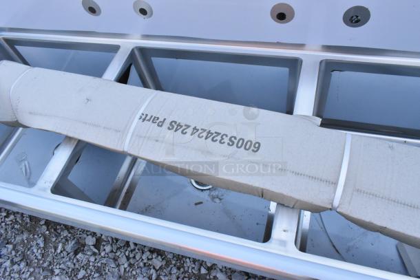 Brand new Regency 600S3242424S stainless steel 3-bay sink with dual drainboards, labeled as parts, minor dent visible.