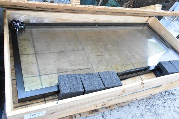 Brand new glass merchandiser door, in packaging with protective foam. Black frame, ready for installation.