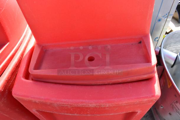 Red poly single tap dispensing system with commercial casters, visible scuffs, no visible branding or markings.