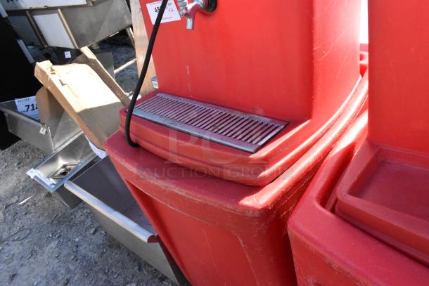 2 red poly single tap dispensing systems on commercial casters with drip trays. Scratches visible, ideal for events.