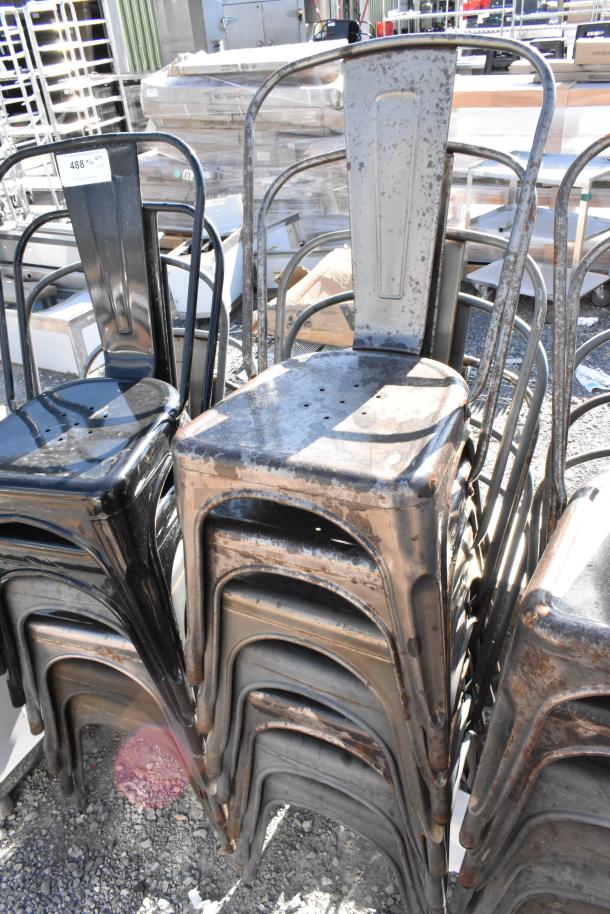 Stack of 19 brand new scratch and dent metal Tolix style chairs. Durable, industrial design with minor blemishes visible.