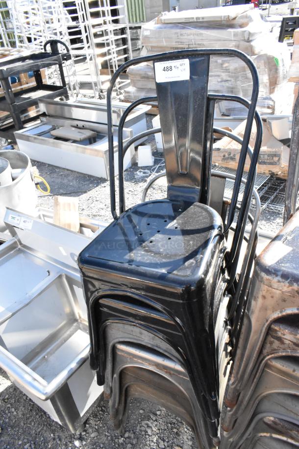 Stack of 19 black metal Tolix-style chairs, brand new with minor scratches and dents. Auction tag showing lot number 488.