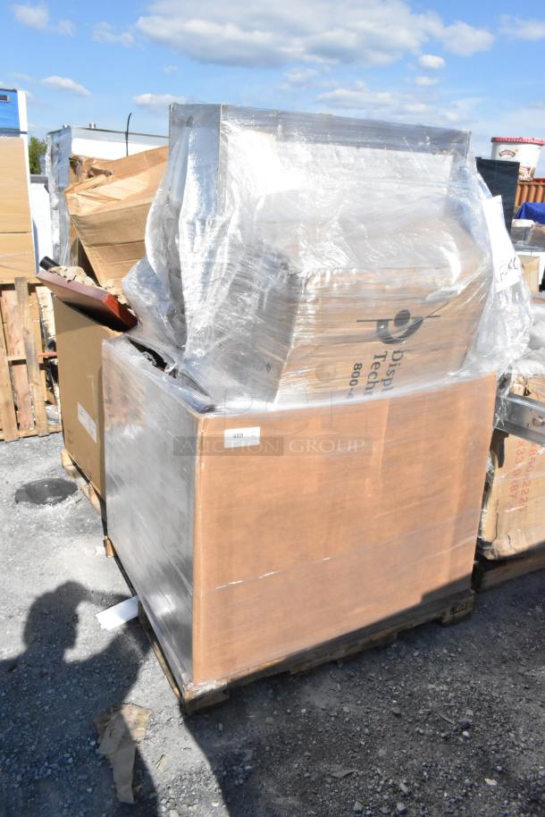 Wrapped pallet of 18 brand new scratch and dent items, various boxes, ready for auction, outdoor setting.