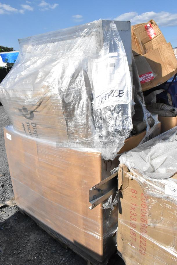 Bulk lot of 18 brand new scratch and dent items wrapped in plastic on a pallet. Includes visible cardboard packaging with "FRAGILE" tags.