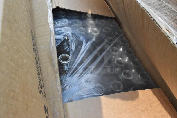 Open box of brand new items including Captiva bottles, partially visible under plastic wrap. Scratch and dent condition.