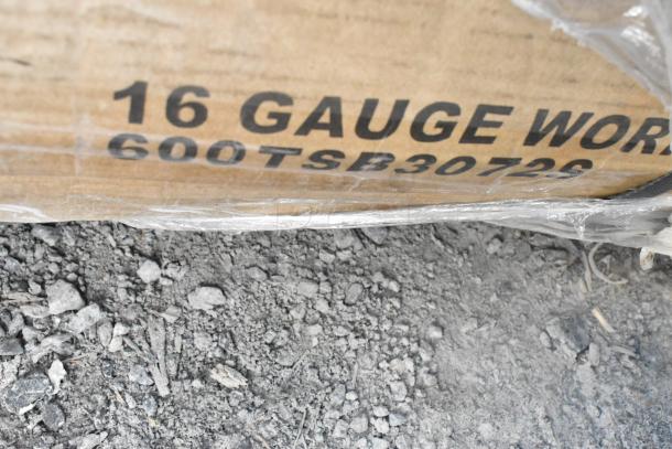 Alt Text: Cardboard box with text "16 GAUGE WORK, 600TSB30726," packaging for stainless steel work tables.
