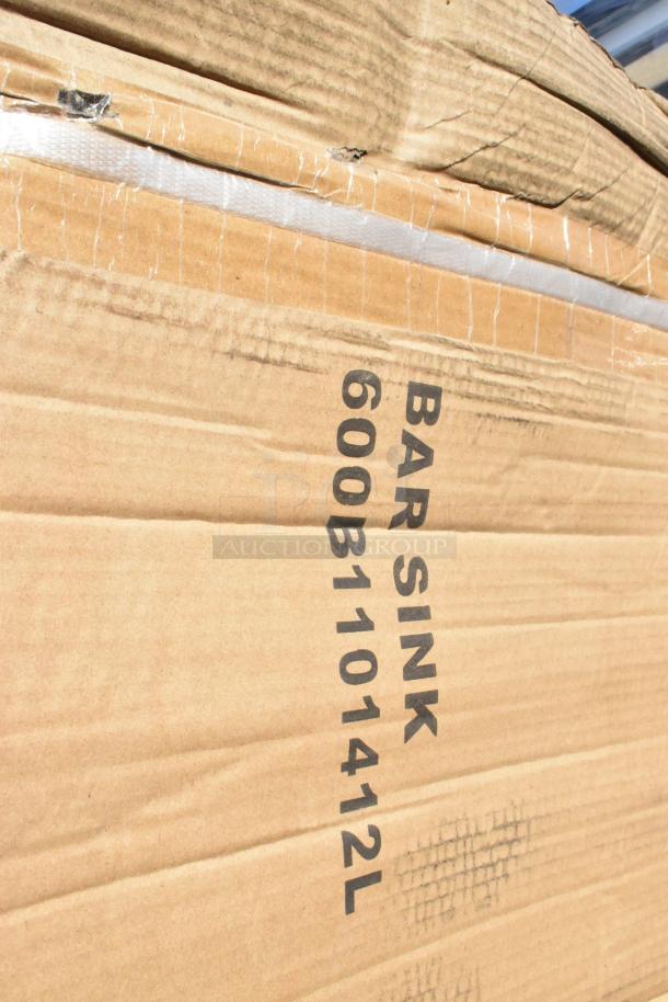 Cardboard box labeled "BAR SINK 600B1101412L," indicating a Regency sink inside. Box shows minor wear, part of a new scratch and dent lot.