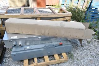 Metal power box with levers and two additional items, including a cardboard box, on a wooden pallet.