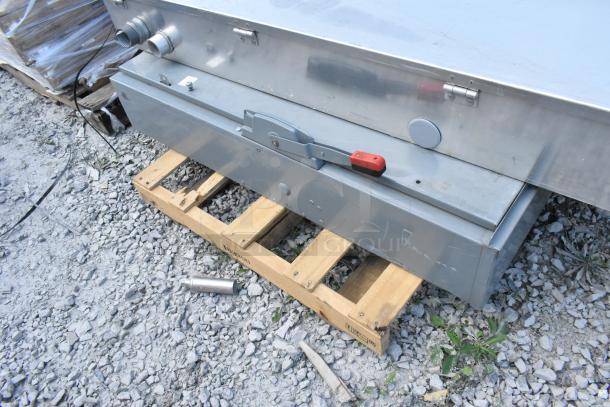 Metal power box on wooden pallet, featuring a red and gray handle, showing signs of wear, auction lot includes three items.