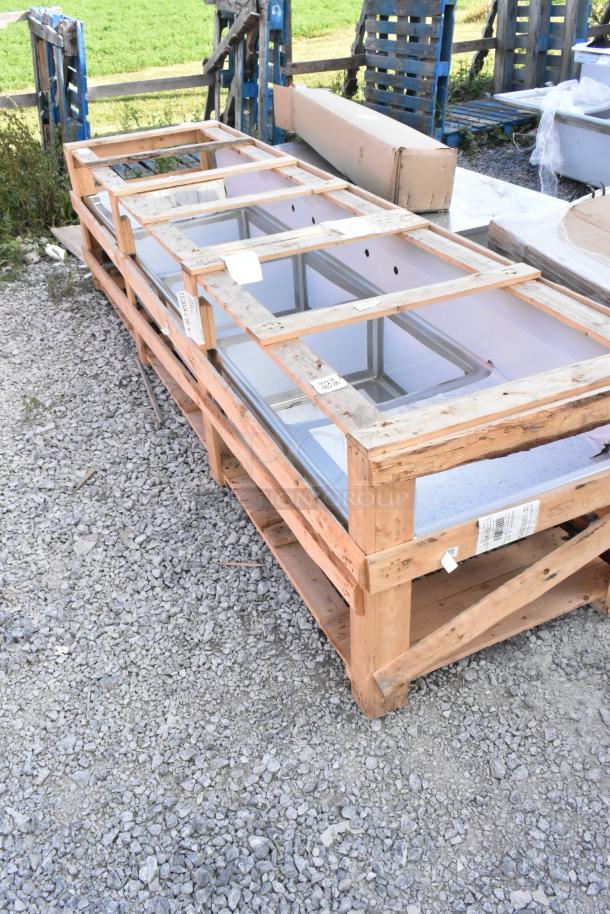 BRAND NEW 2024 Elkay Stainless Steel 3 Bay Sink with Dual Drain Boards, slightly scratched and dented, on wooden pallet.