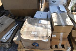 Boxes of new items, including hot dog holders and anti-fatigue floor mats, labeled "7014," on a wooden pallet.