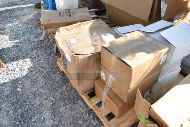 8 brand new scratch and dent boxes on a pallet, including 7014 hot dog holders and a black anti-fatigue floor mat.