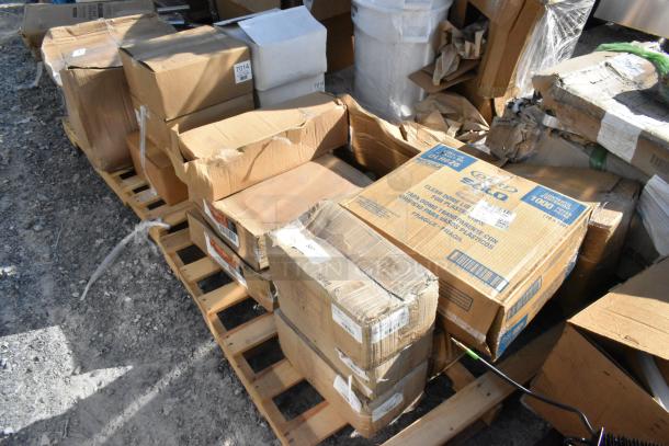 Boxes of brand new, scratch and dent items on a pallet, including Dart lids, 3M pads, MERGH24S handle, and stanchion with belt. Boxes have visible wear.