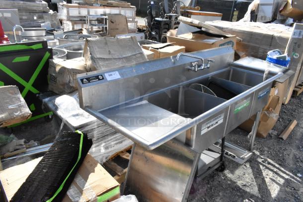Stainless Steel 3 Bay Sink with left side drain board, labeled 500, includes faucets, visible wear, ideal for commercial use.