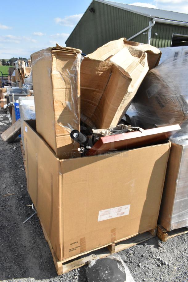 Large cardboard boxes containing metal Tolix style chairs, labeled as "scratch and dent," on a pallet.