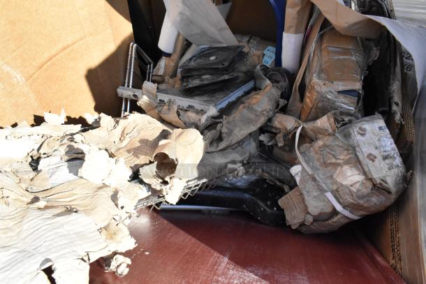 Cardboard boxes and packing materials, slightly damaged, showing signs of wear. Contents include Tolix-style chairs.