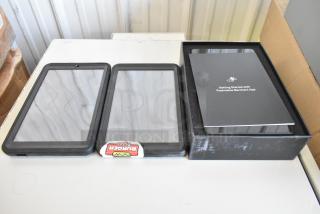 3 tablets in protective cases, one with "Burger Blip" label, and another boxed with Postmates Merchant App guide.