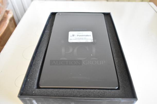Three Samsung tablets in original packaging, labeled "Property of Postmates," indicating prior corporate use.