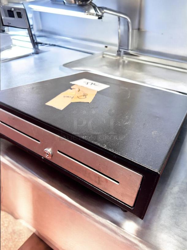 APG Cash Drawer Model VBS579-BL1616, excellent condition, tested, black with metal slots, includes keys and markings.
