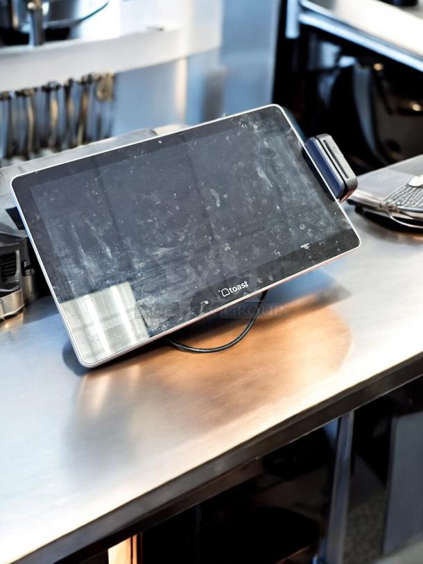 Toast POS Touchscreen System in excellent condition on stainless steel counter, screen smudges visible, fully tested and working.